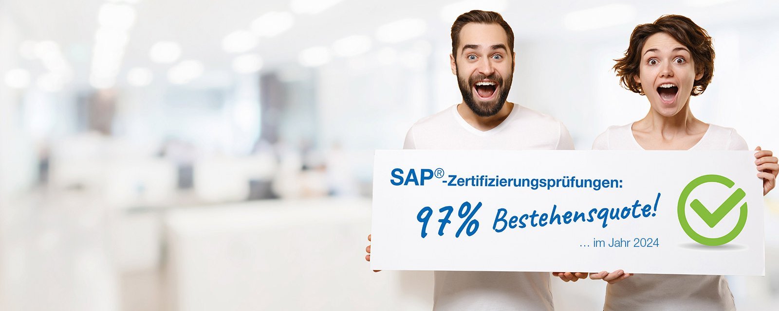 2 Personen halten ein Schild mit der Bestehensquote von SAP Prüfungen