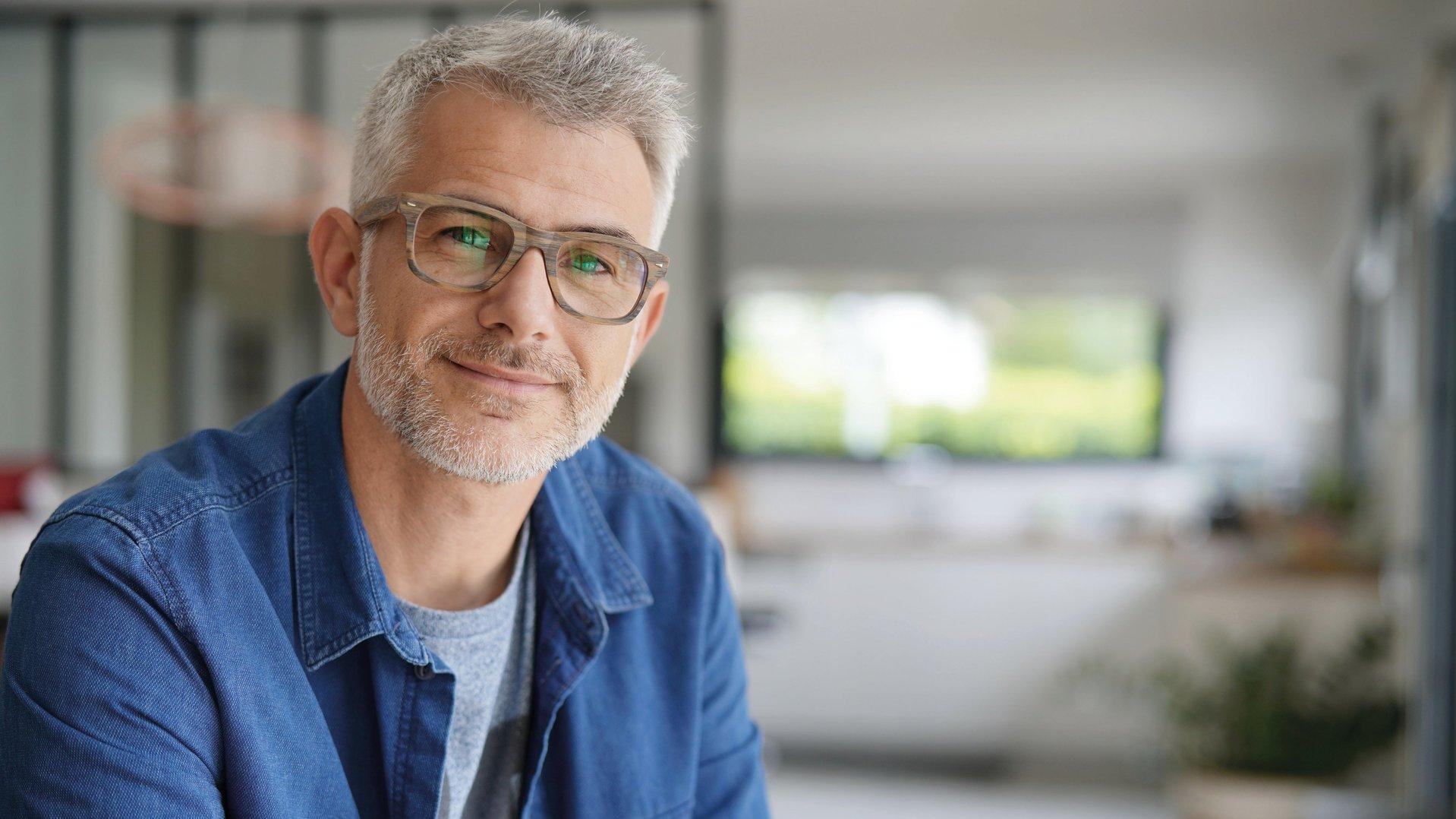 ein Dozent mit Brille lächelt freundlich