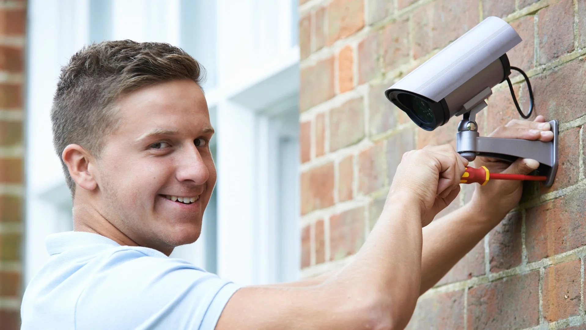 Ein Mann bringt eine Außenleuchte an